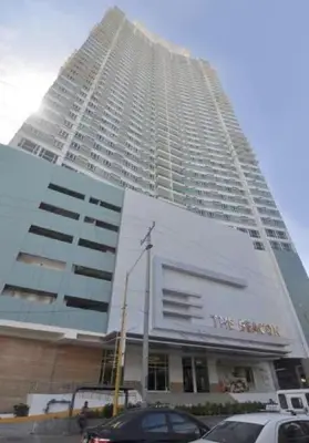 a tall building with cars parked in front of it at Amora Suites at the Beacon Makati in Manila
