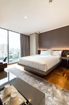 a bedroom with a large bed and a large window at Ramada Encore by Wyndham Makati in Manila