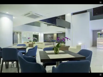 a dining room with blue chairs and a table with purple flowers at Ramada Encore by Wyndham Makati in Manila