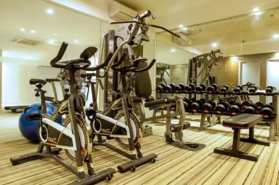 a gym with several bikes and weights at Ramada Encore by Wyndham Makati in Manila