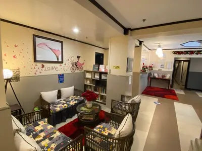 a large living room with couches and a tv at Amax Inn Makati in Manila