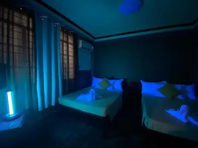 a dark room with two beds with blue lights at Amax Inn Makati in Manila