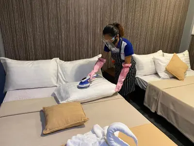 a woman in a room with two beds at Amax Inn Makati in Manila