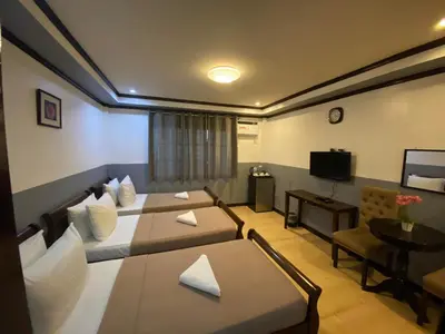 a hotel room with two beds and a television at Amax Inn Makati in Manila