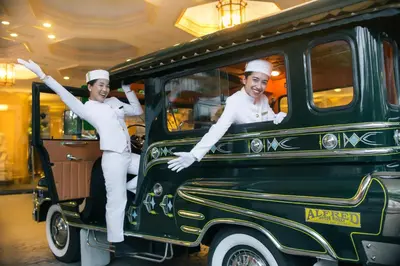 two chefs are riding in an old car at The Peninsula Manila in Manila