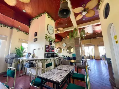 a restaurant with a table and chairs in a room at Chanel Paris Hotel powered by Cocotel in Manila