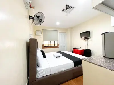 a hotel room with a bed and a tv at Chanel Paris Hotel powered by Cocotel in Manila