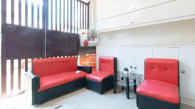 a waiting room with two red chairs and a table at RedDoorz near NAIA Terminal 1 in Manila