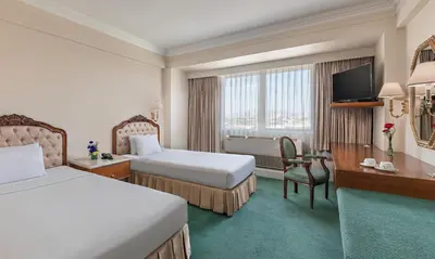 a hotel room with two beds and a television at Manila Prince Hotel in Manila