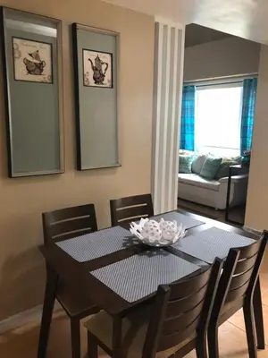 a dining room with a black table and chairs at Loft condo beside Shangri-La Fort in Manila