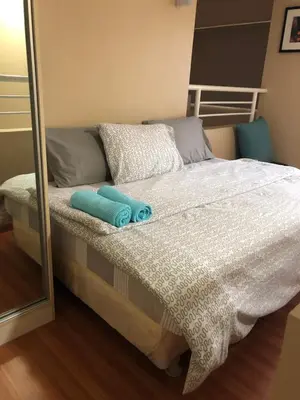 a bed with two towels on it in a bedroom at Loft condo beside Shangri-La Fort in Manila