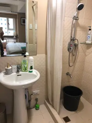 a bathroom with a sink and a shower at Loft condo beside Shangri-La Fort in Manila