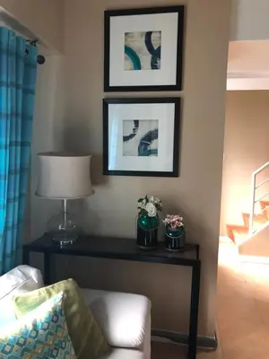 a living room with a table and a lamp at Loft condo beside Shangri-La Fort in Manila