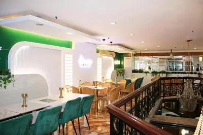 a restaurant with tables and chairs and a bar at Lourdes Family Suites Makati powered by Cocotel in Manila