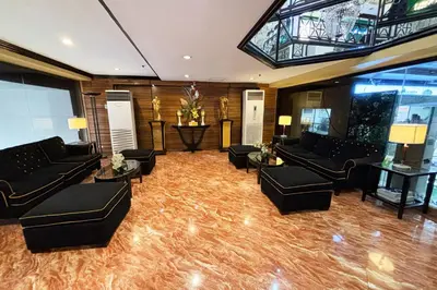a large living room with couches and tables at Lourdes Family Suites Makati powered by Cocotel in Manila