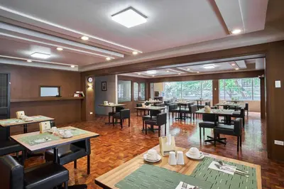 a restaurant with tables and chairs in a room at Tropicana Suites in Manila