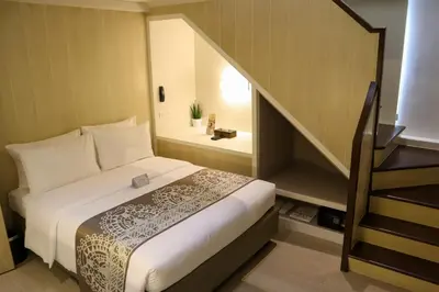 a bedroom with a bed and a stair case at Mella Hotel Manila near NAIA Airport in Manila