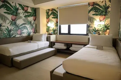 a hotel room with two beds and a window at Mella Hotel Manila near NAIA Airport in Manila
