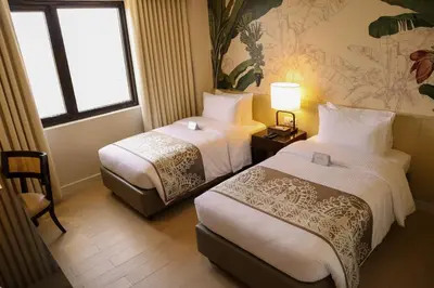 a hotel room with two beds and a window at Mella Hotel Manila near NAIA Airport in Manila
