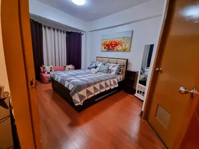 a bedroom with a bed and a television in it at Legarse Staycation at Montecito Residential Resort in Manila