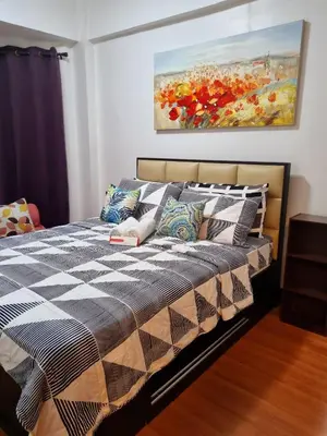 a bedroom with a bed with a painting on the wall at Legarse Staycation at Montecito Residential Resort in Manila