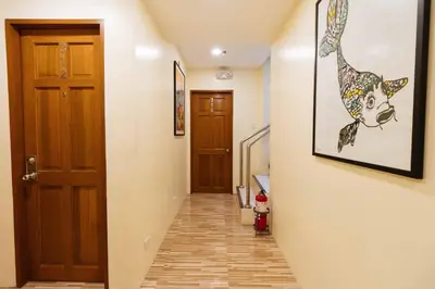 a hallway with a door and a picture of a cow on the wall at RedDoorz at Hotel Rosemarie in Manila