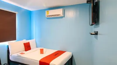 a room with a bed with a blue wall at RedDoorz at Hotel Rosemarie in Manila