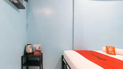 a room with a bed and a table with a phone at RedDoorz at Hotel Rosemarie in Manila