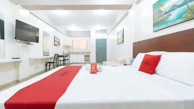 a large white bed with red pillows in a room at RedDoorz near Pasay Taft in Manila