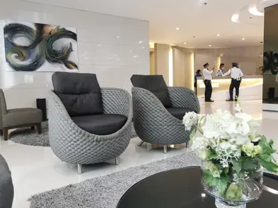 a lobby with chairs and a vase of flowers on a table at Liam's Pad at grace residences in Manila