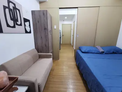 a room with a couch and a couch and a bed at Liam's Pad at grace residences in Manila