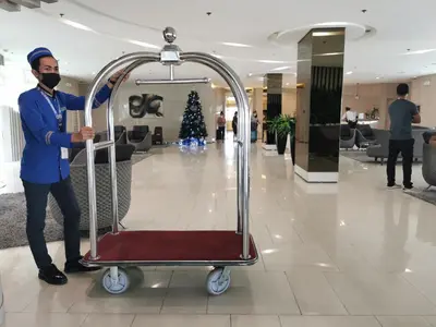 a man pushing a luggage cart in a mall at Liam's Pad at grace residences in Manila