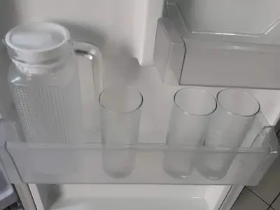 an empty refrigerator with some cups in it at 1BR with Balcony Overlooking Pool Chateau Elysee Near NAIA in Manila
