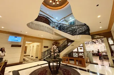 a lobby with a spiral staircase in a building at Tiara Oriental Hotel Makati powered by Cocotel in Manila