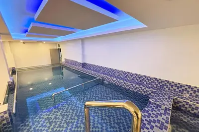 a swimming pool in a room with a blue ceiling at Tiara Oriental Hotel Makati powered by Cocotel in Manila