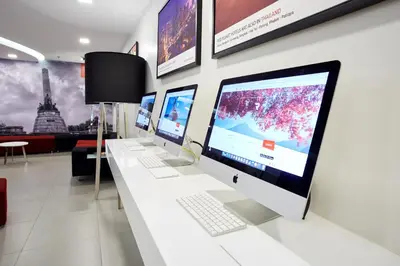 a row of computer monitors on a white counter at Red Planet Manila Malate Mabini in Manila