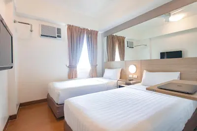 a hotel room with two beds and a window at Red Planet Manila Malate Mabini in Manila