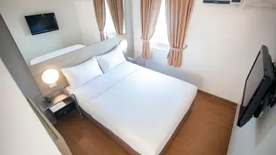 a small bedroom with a bed and a tv at Red Planet Manila Malate Mabini in Manila
