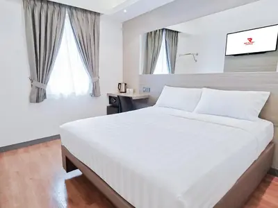 a white bedroom with a large bed and windows at Red Planet Manila Malate Mabini in Manila