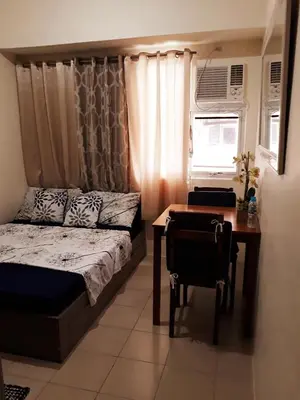 a bedroom with a bed and a desk and a table at Mandaluyong Stays Inn in Manila