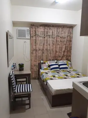 a small bedroom with a bed and a chair at Mandaluyong Stays Inn in Manila