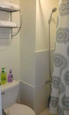 a bathroom with a toilet and a shower curtain at Mandaluyong Stays Inn in Manila