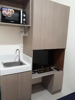 a small kitchen with a sink and a microwave at Mandaluyong Stays Inn in Manila
