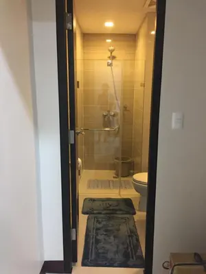 a bathroom with a toilet and a glass shower at 101 Newport Boulevard C3 in Manila