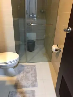 a bathroom with a toilet and a glass shower at 101 Newport Boulevard C3 in Manila