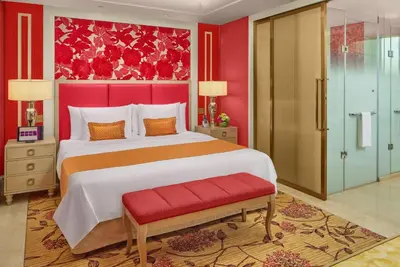 a bedroom with a large bed with a red wall at Okada Manila in Manila