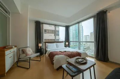 a bedroom with a bed and a large window at Prime Avant BGC Location Apartments by PH Staycation in Manila