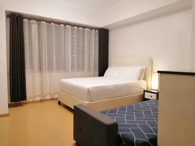a bedroom with a bed and a large window at Prime Avant BGC Location Apartments by PH Staycation in Manila