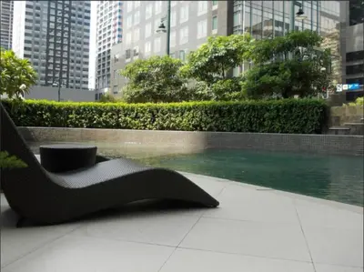 a black chair sitting on a sidewalk in a city at Prime Avant BGC Location Apartments by PH Staycation in Manila