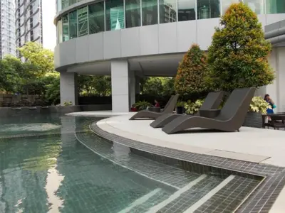 a building with benches in front of a pool of water at Prime Avant BGC Location Apartments by PH Staycation in Manila